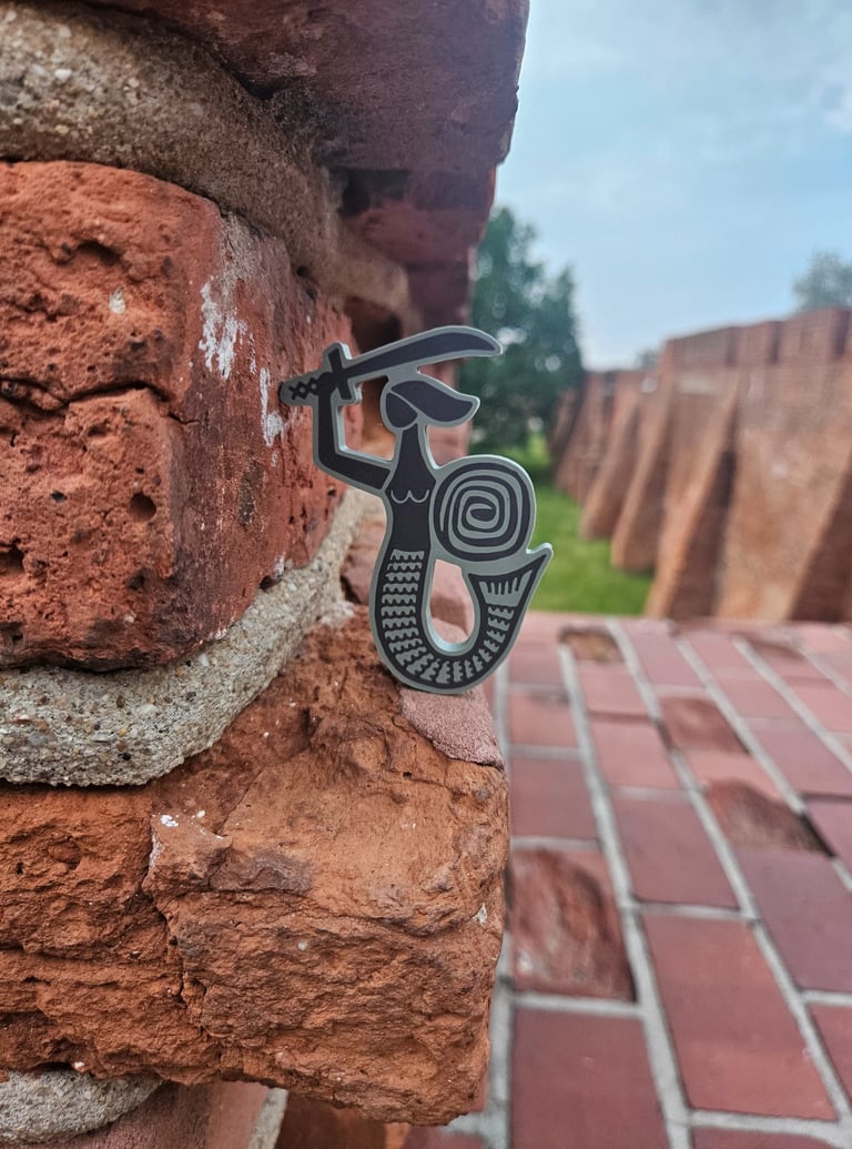 Zielona syrenka na tle Barbakanu