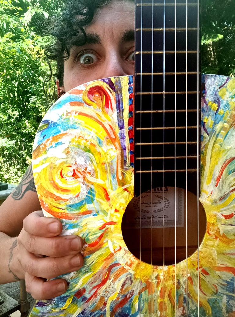 Naia qui tient Suun - une peinture sur guitare très colorée