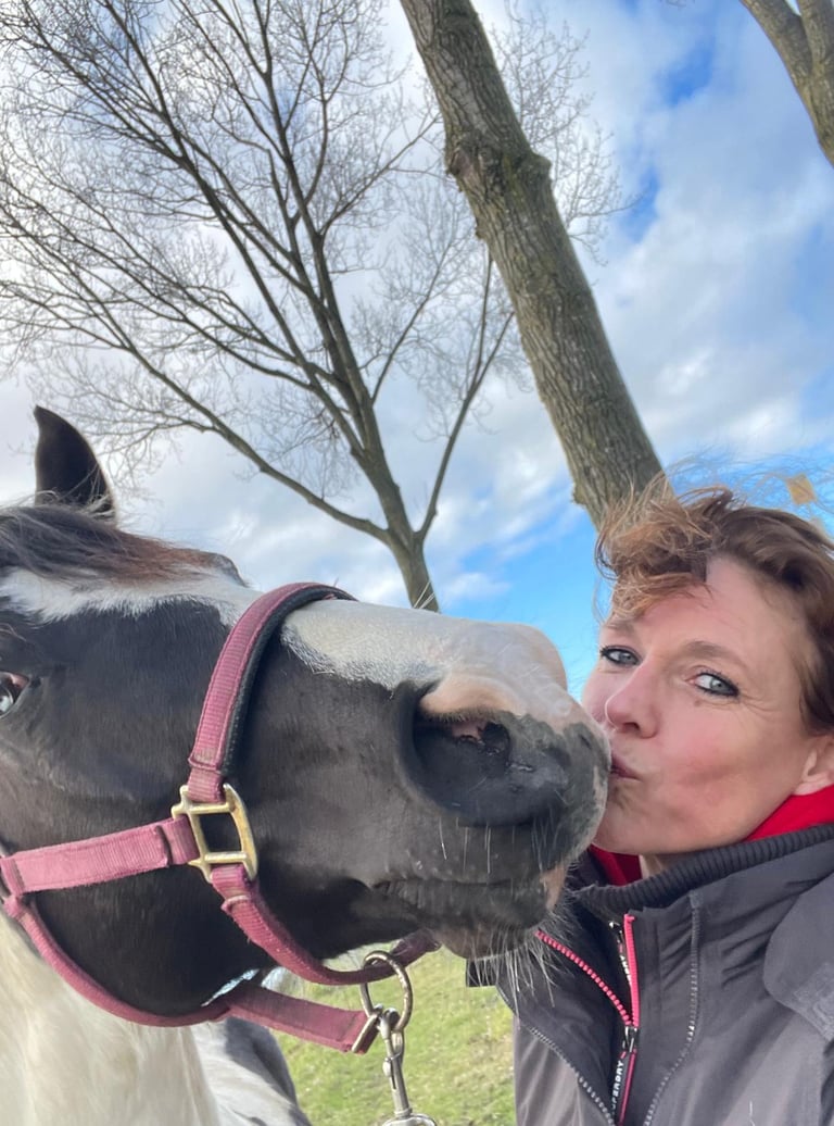 Vrouw geeft paard een kus