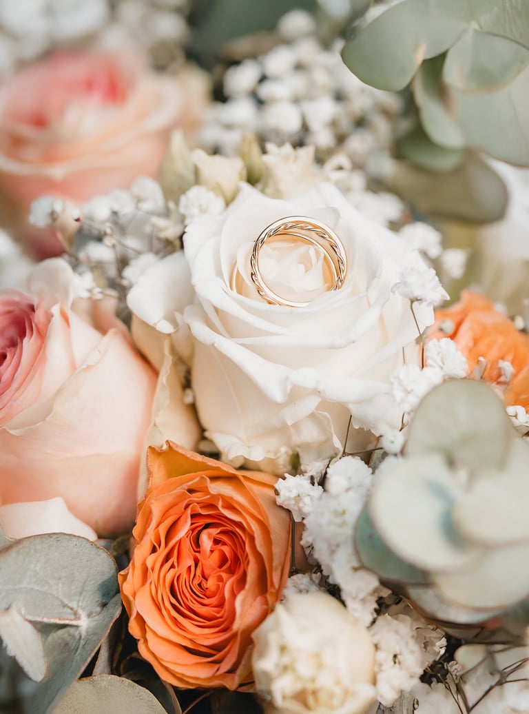 a bouquet of flowers with a wedding ring