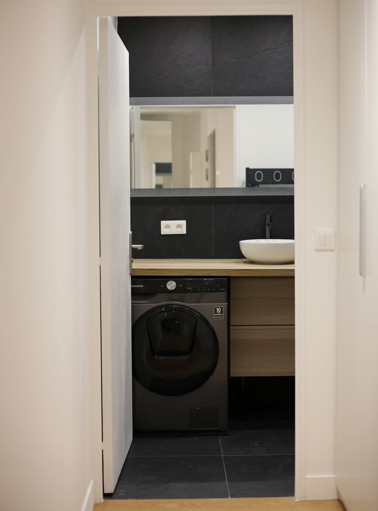 a washer in a bathroom with a sink and a washer