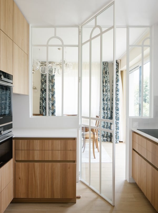 a kitchen with a large window and a table with chairs