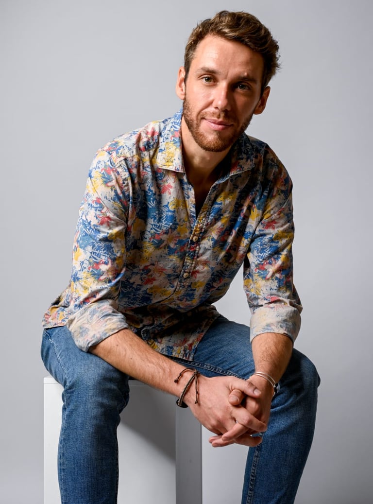 Monsieur rêve architecte, vêtu d'une chemise boutonnée à imprimé floral coloré et d'un jean bleu