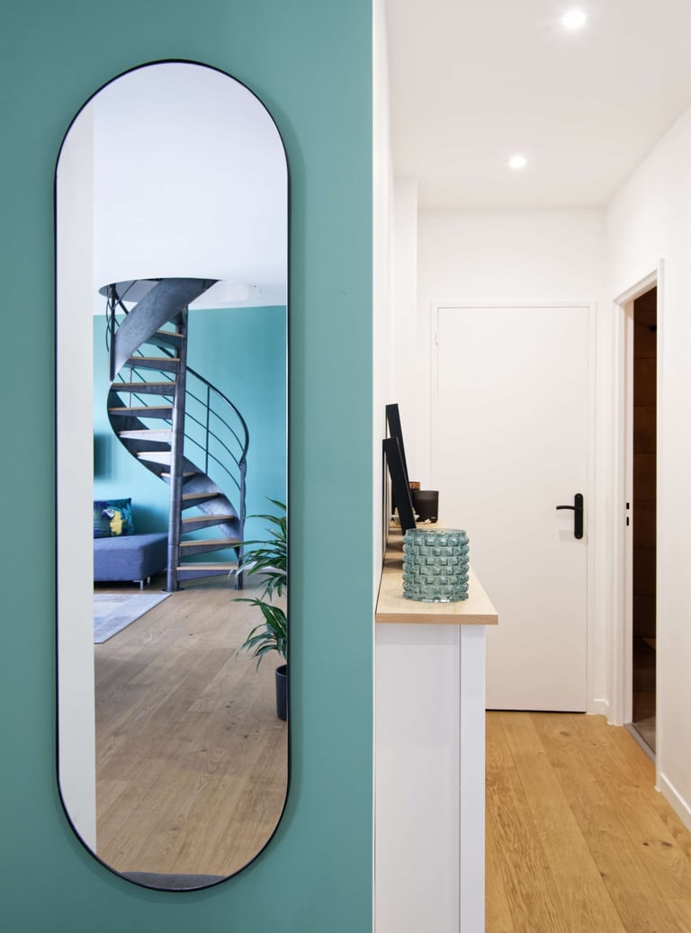 a mirror reflecting a spiral staircase in a hallway