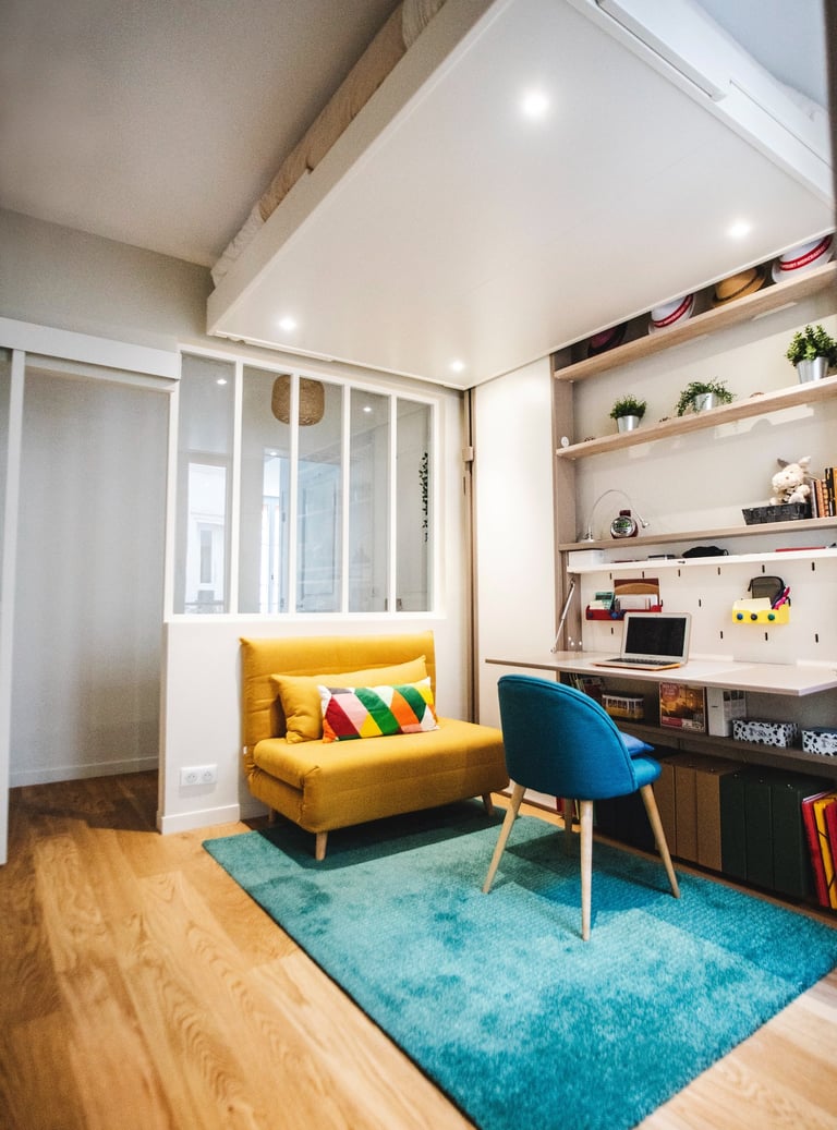 a yellow couch in a room with a blue rug