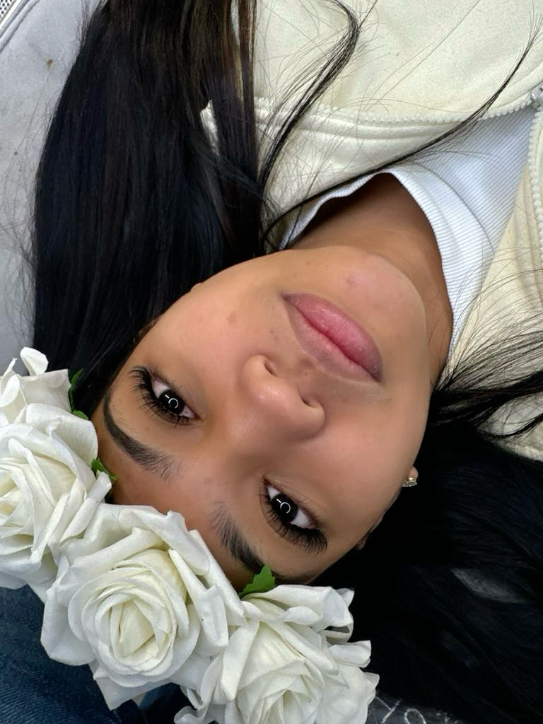 a woman laying on a couch with flowers in her hair