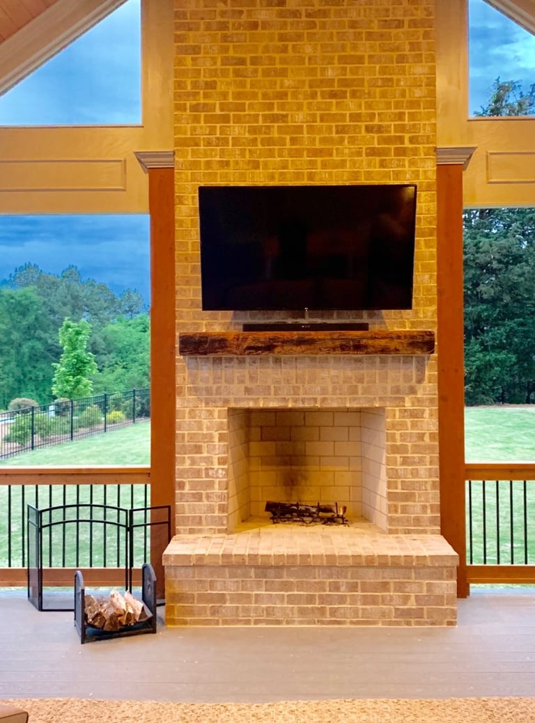 outdoor tv mounted over a brick fireplace