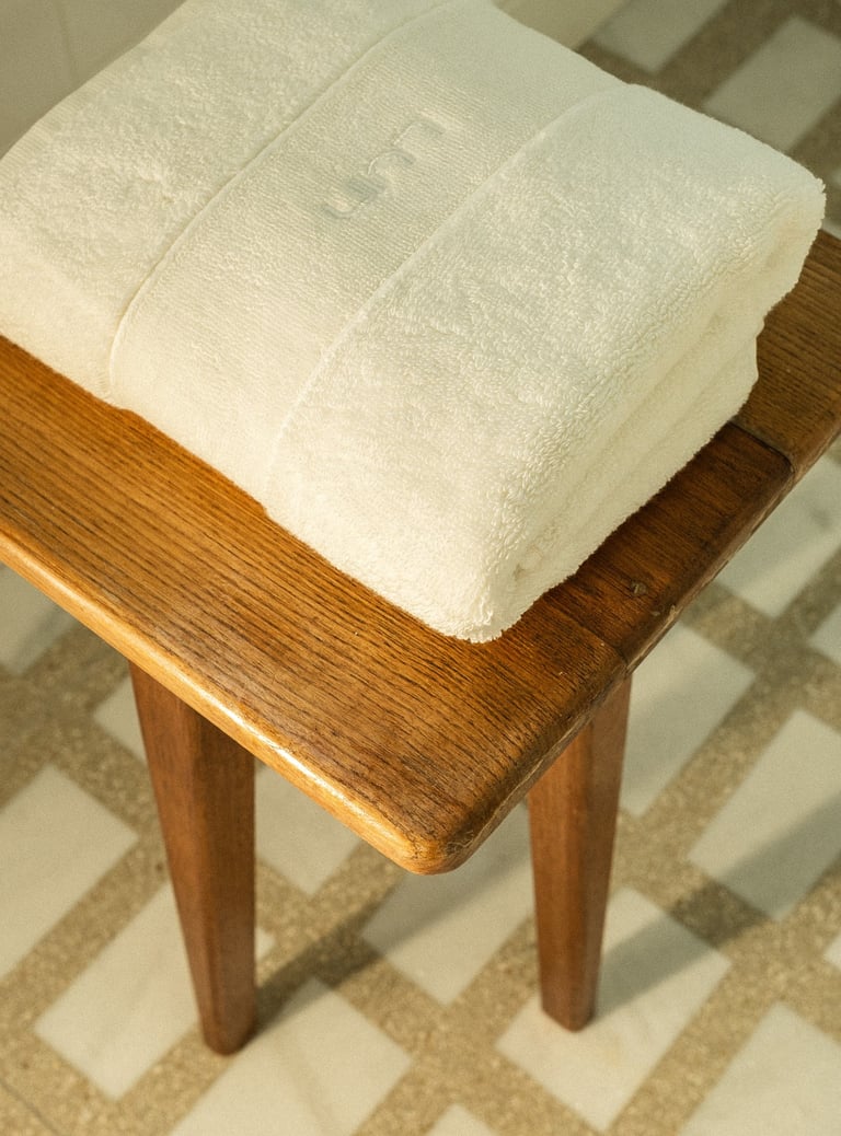 Tabouret en bois sur sol en marbre Carlo Scarpa dans une salle de bain sur mesure à Paris