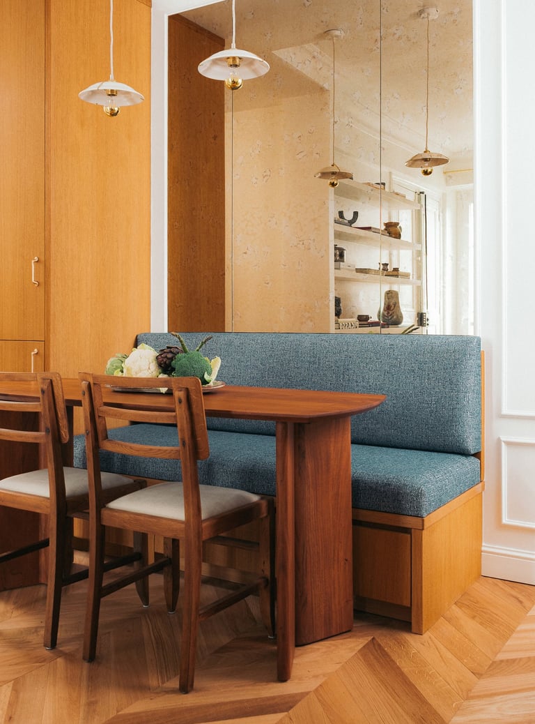 Coin repas avec banquette sur mesure, miroir vieilli, table en noyer et chaises Pierre Cruège