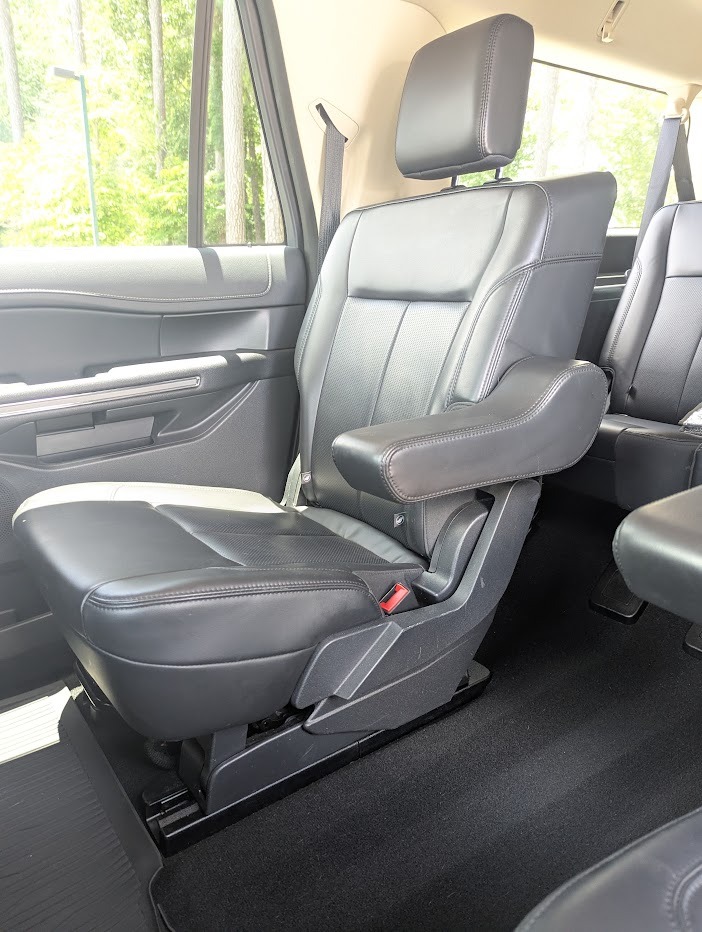 Spacious black leather captain's chair in the second row of a luxury SUV interior.