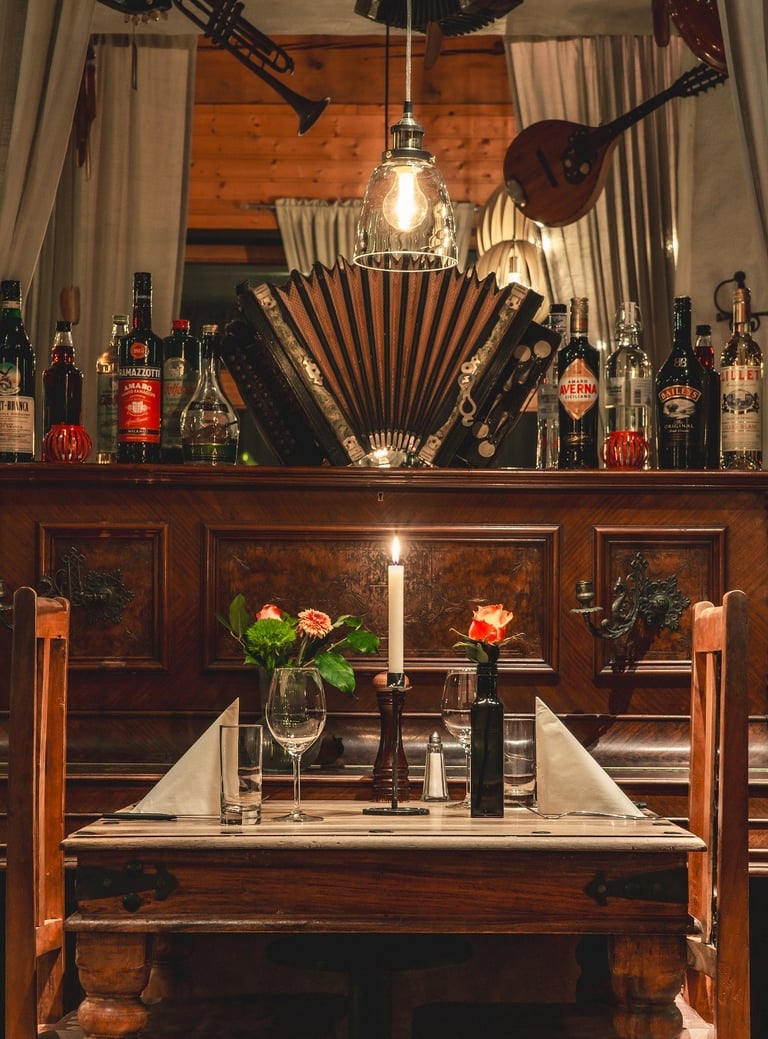 Romantisch gedeckter Tisch für zwei im rustikalen Restaurant mit Kerzenlicht und Musikinstrumenten.