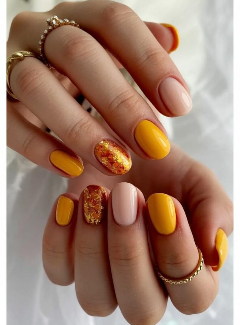 Mustard yellow and beige nails with glitter foil and autumn leaf design – vibrant and trendy fall na