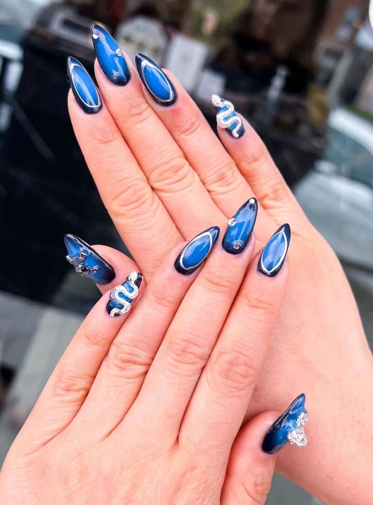 Deep navy and blue ombre fall nails with silver 3D crystal snake accents.