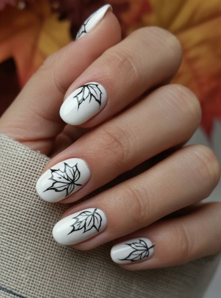 Short white fall nails with black botanical line art on accent nails.
