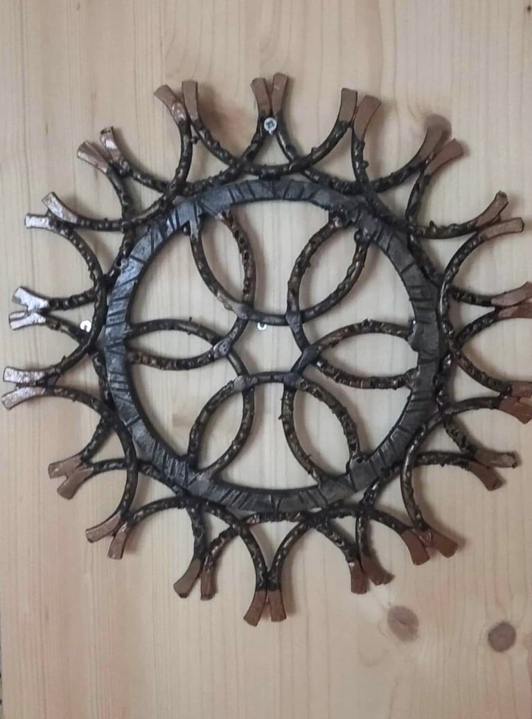 Rankų darbo metalinė saulutė užsakovų namuose. Skirta modernaus namų interjero dekoravimui