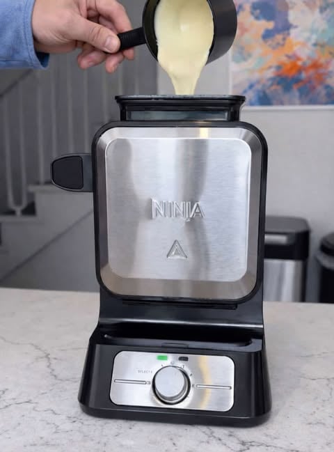 Ninja countertop waffle maker with mixture being poured into top container