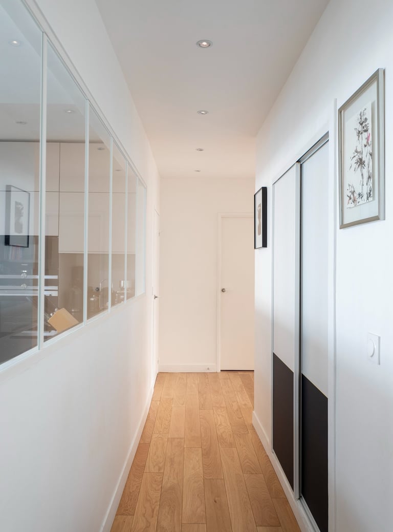a hallway with a wooden floor and a white door