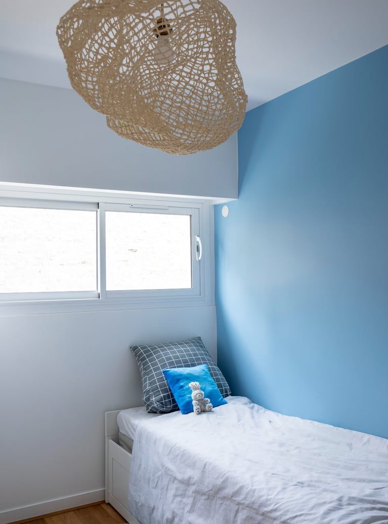 a bedroom with a bed and a lamp