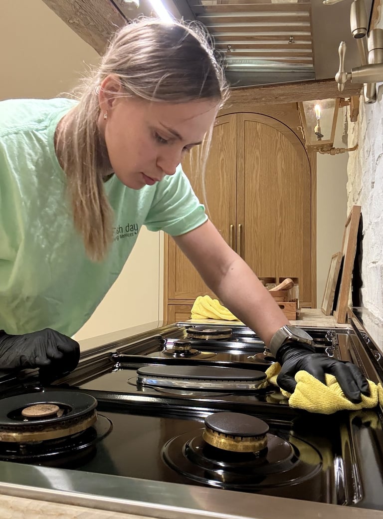 A professional cleaner expertly cleans the cooktop