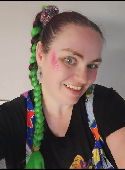 a woman with green hair and pink makeup