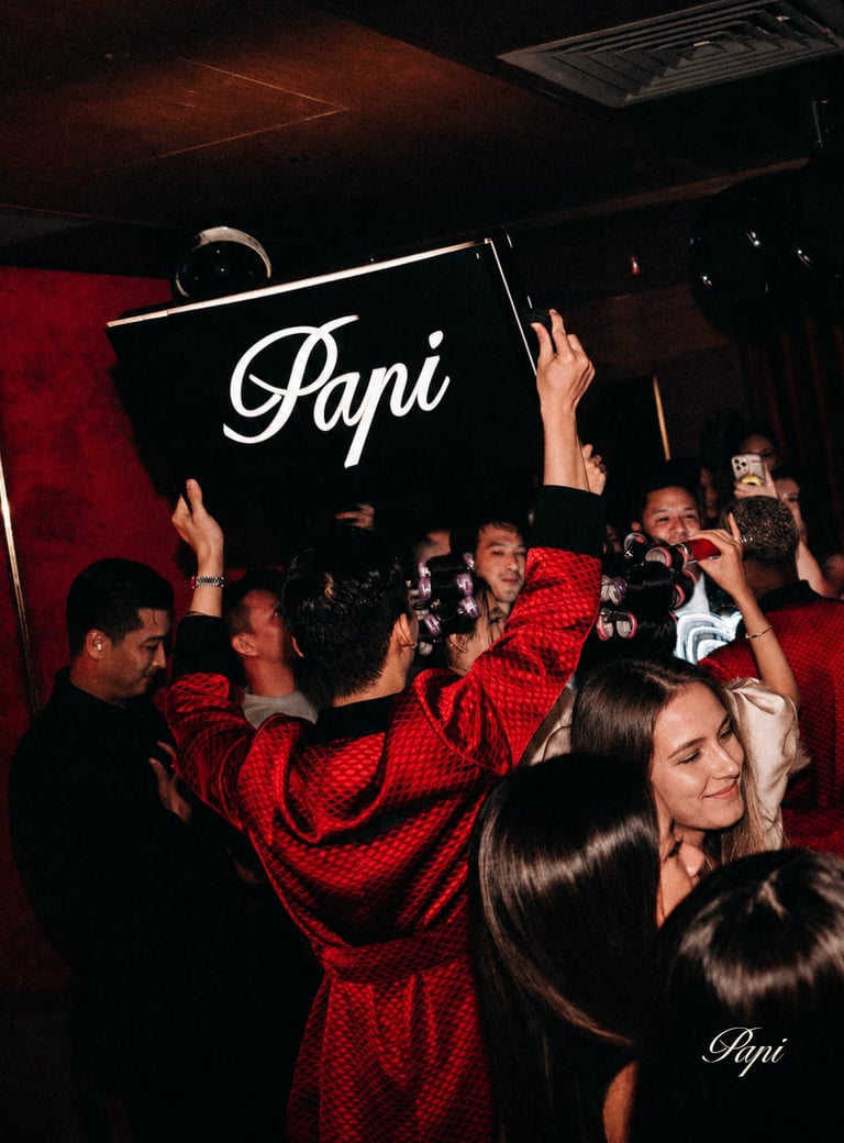 Papi Saigon holding a Papi sign providing Bottle service to clients