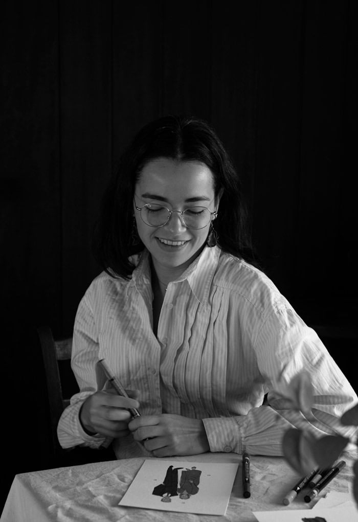 Fotografia en blanco y negro de Ana de Studio Anneta pintando un retrato y sonriendo