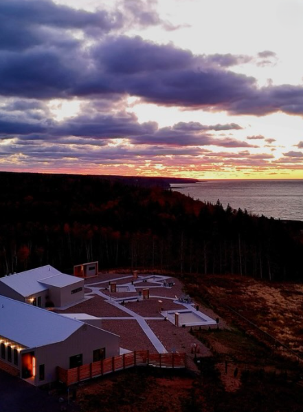 Aerial view of a Saltair Nordic Spa & Wellness during dramatic sunset over the ocean.