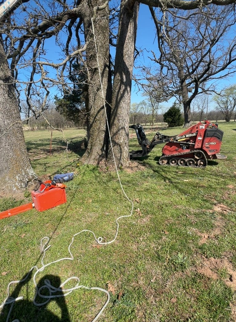 Mini Skid steer chainsaw and rope being used for tree removal in Jay Oklahoma