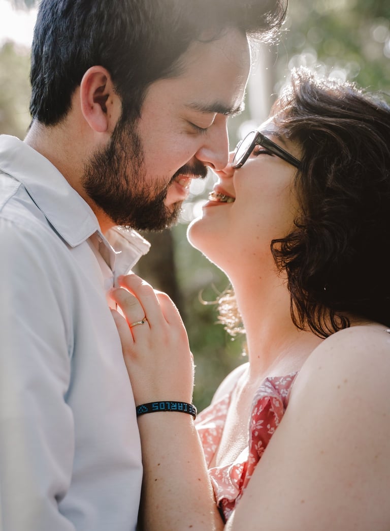 a man and woman kissing in a park