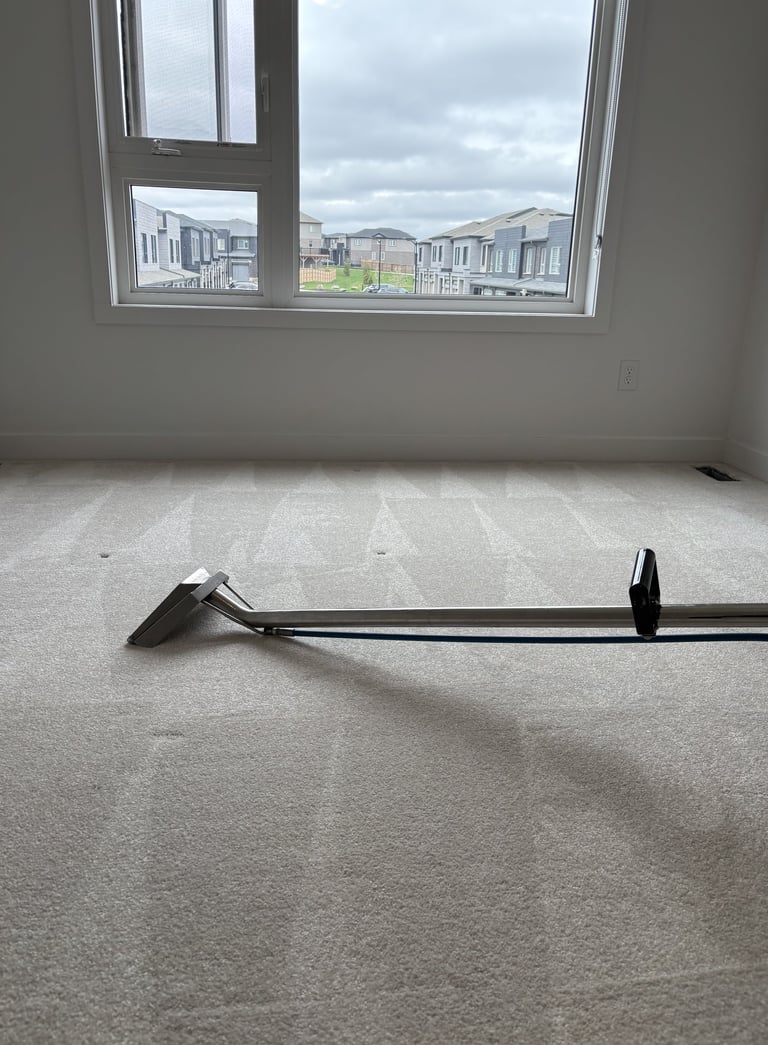 Carpet cleaning wand in use during a deep steam cleaning service on a residential carpeted floor.