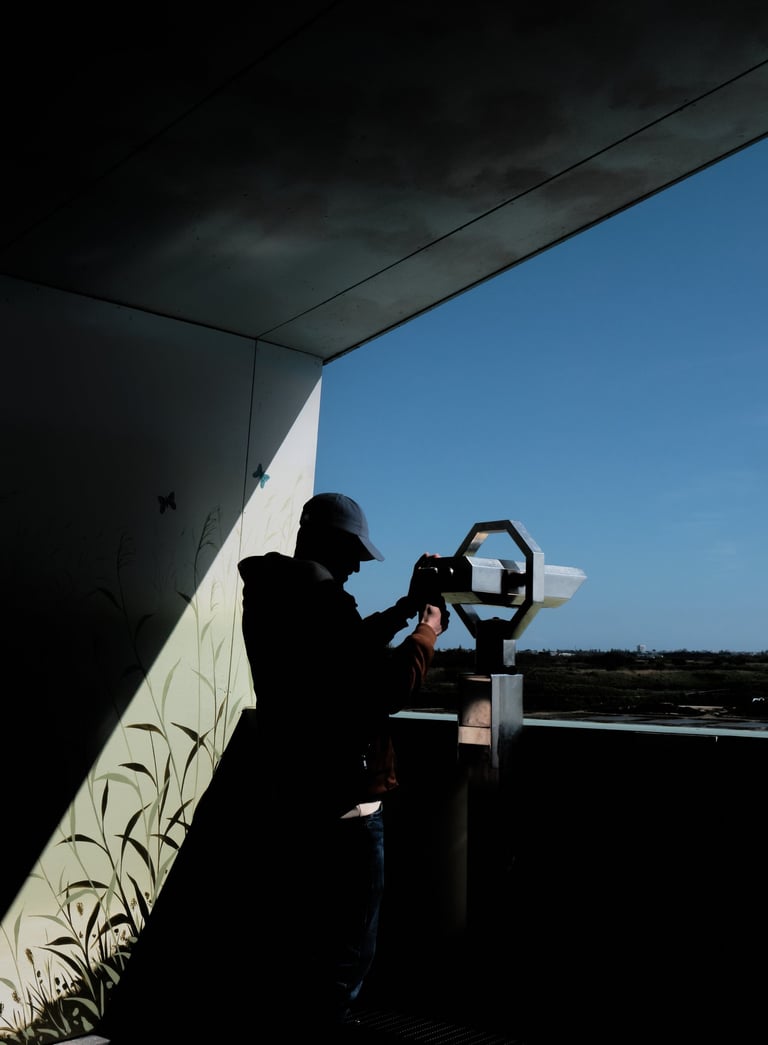 a man standing in front of binoculars