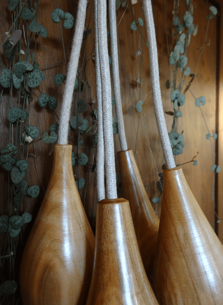 houten lampfittingen met snoer en planten op de achtergrond