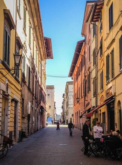 Colorful street with cafes and historic buildings in Pietrasanta Tuscany Italy.