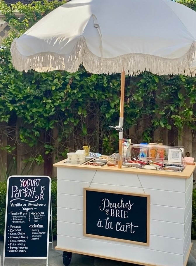 Yogurt parfait bar cart with umbrella at a party