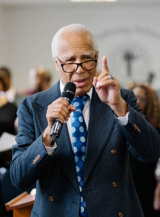 Light coloured skin man in suit holding a microphone