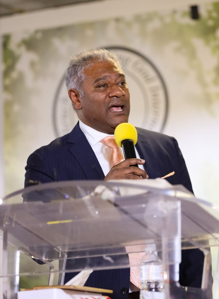Male holding a microphone wearing tie and suit