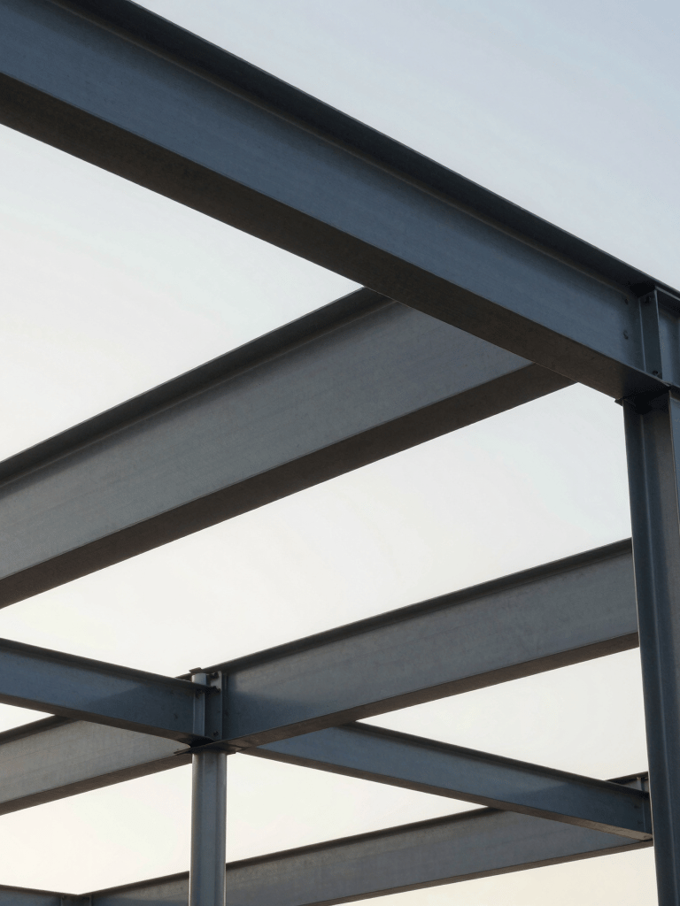 Professional photography of a construction project in Brazil featuring structural steel beams against a bright morning sky, clean and modern composition.