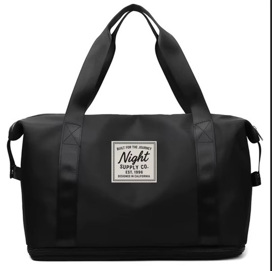 Black duffel bag with dual handles and front Night Supply Co. logo patch, designed in California.