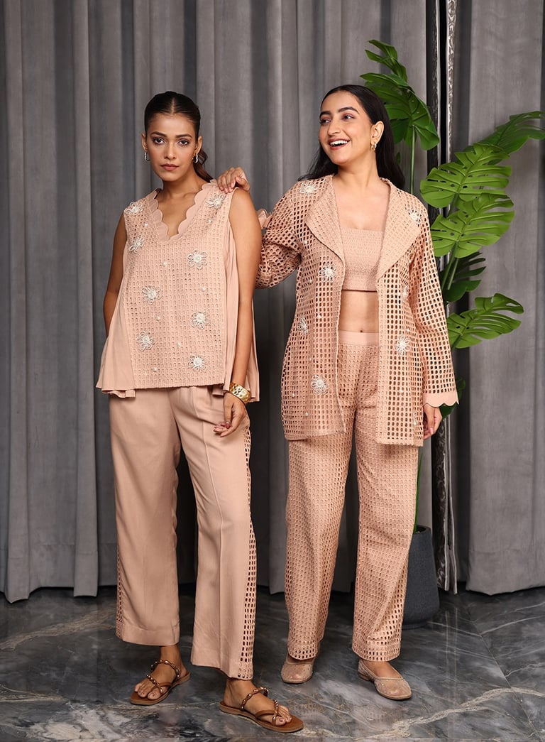 two women in matching pink and beige outfits