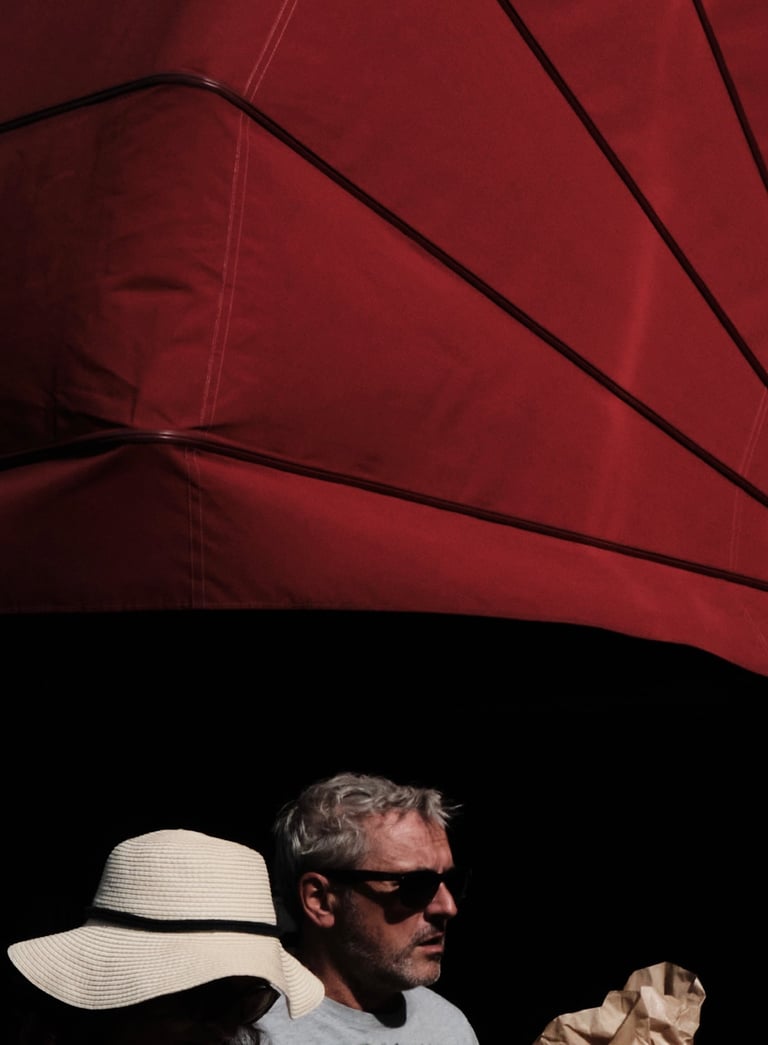 un homme et une femme descendant une rue, avec un store banne d'un café français