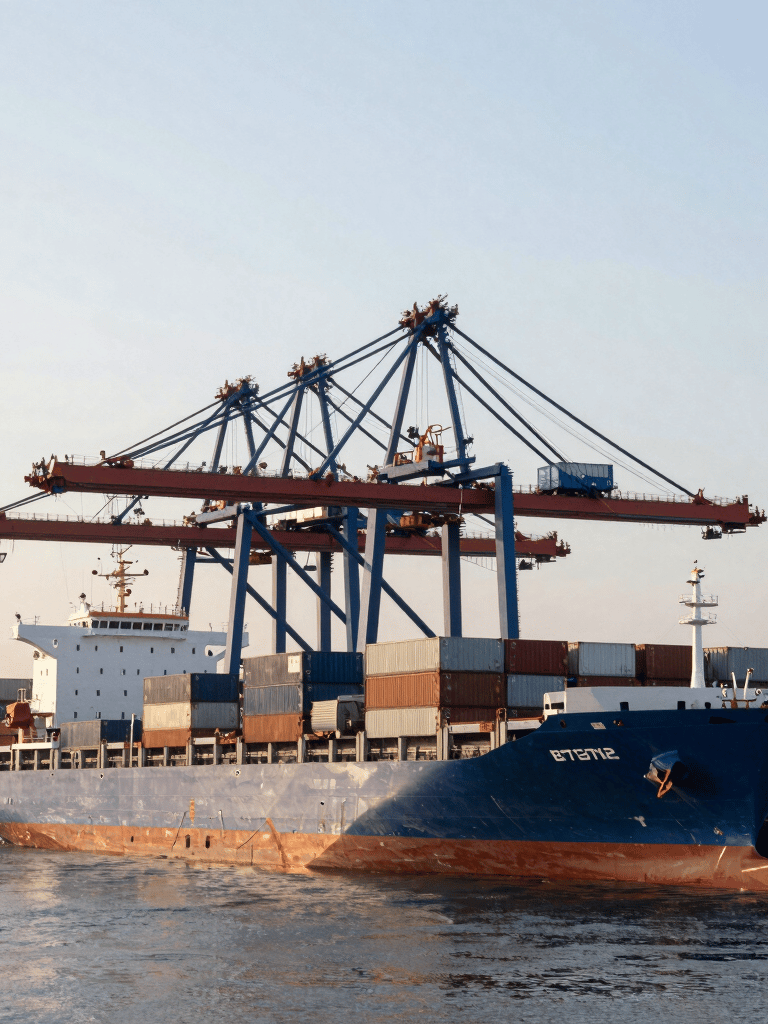 A wide, professional shot of a modern international trade hub with blue cargo ships and cranes at a British port, soft morning light, portraying global connectivity.