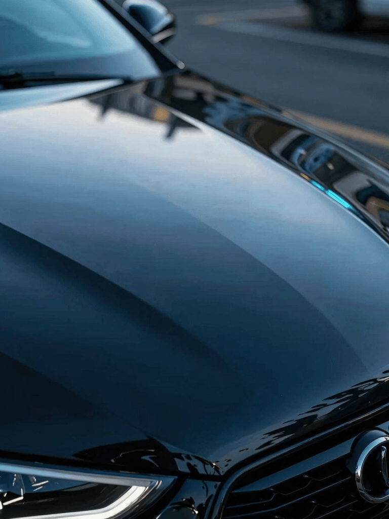 Cinematic macro photography of a glossy black car hood reflecting electric blue neon lights, high-end automotive aesthetics, International / Global.