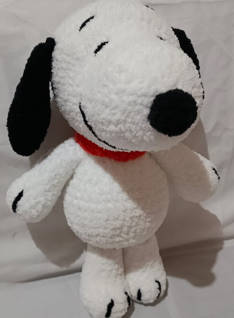 Handmade white crochet Snoopy plush toy with black ears and a red collar.