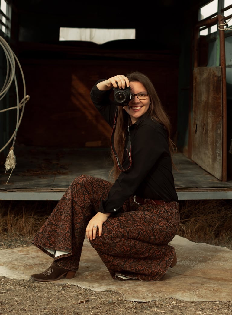woman in western theme holding a camera up to her face