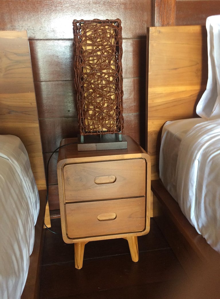 a nightstand with a basket weave basket on top of it