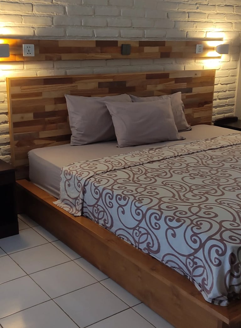 a bed with a bed and a lamp made in singaraja by DharmaJaya Furniture