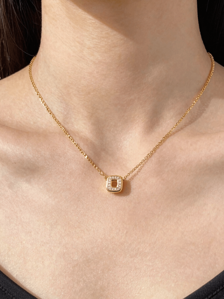 Close-up of elegant gold chain and minimalist ring on a soft black velvet background.