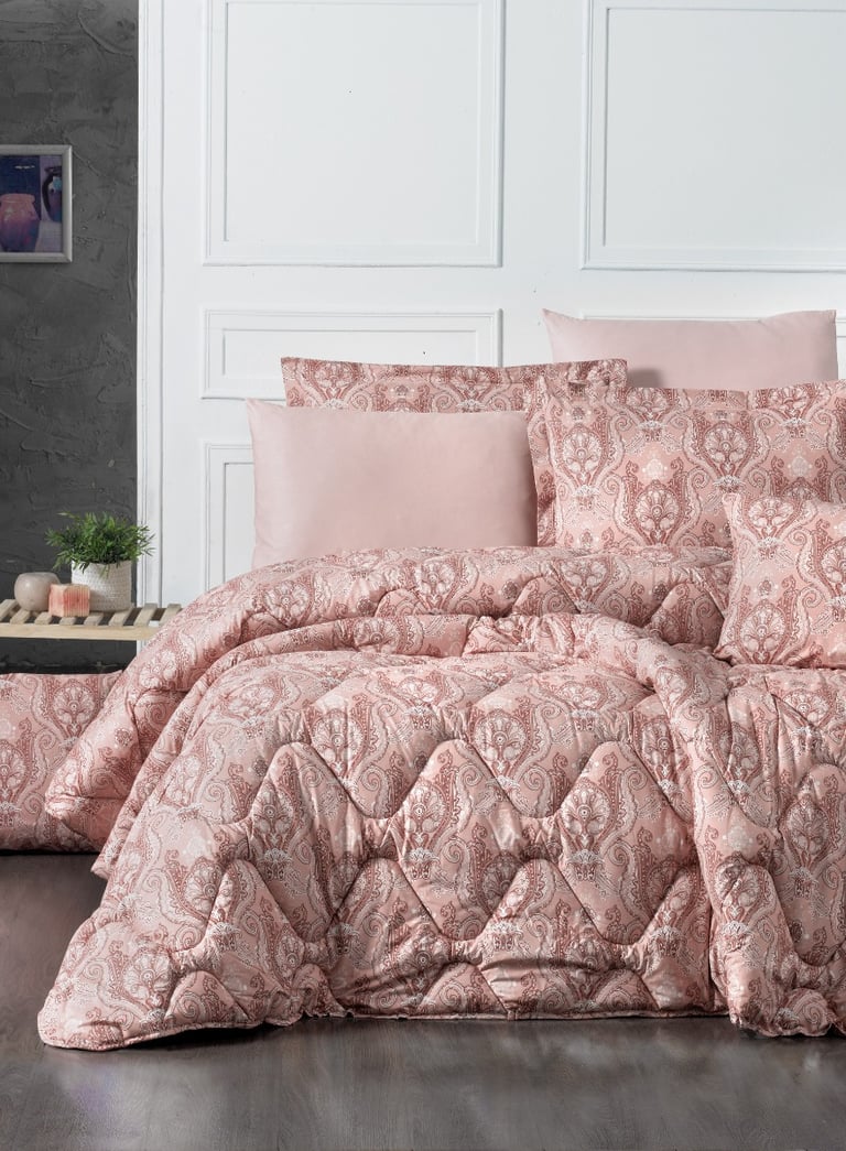 a bed with a pink comforter and pillows