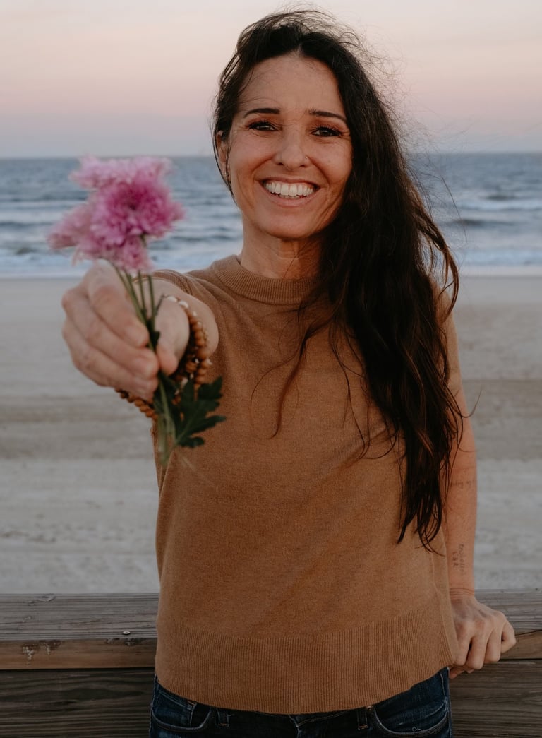 Michael Alexa Pitts Consciousness Advocate at the beach near sunset & offering you a handful of lavender flowers