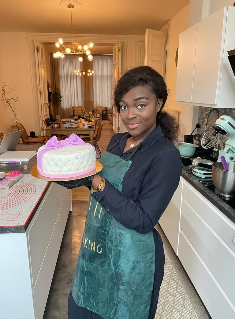 a woman in a green apron holding a cake